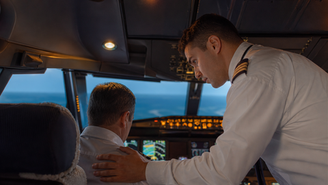 First officer checking on the captain in a cockpit training scenario