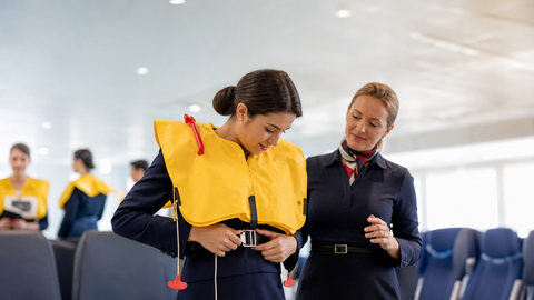 Cabin crew trainee practicing a life vest emergency drill
